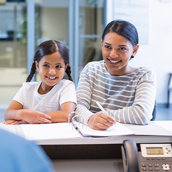 Mother and daughter checking in at reception desk
