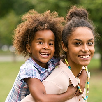 Smiling mother and daughter outdoors