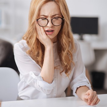 Woman in pain holding jaw