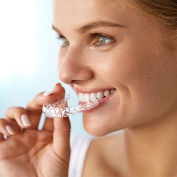 Woman placing invisalign tray