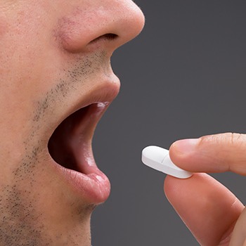 Closeup of patient taking oral sedative pill