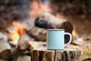 cup of coffee by a campfire 