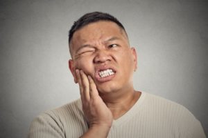 Man with tooth pain put his hand on his cheek