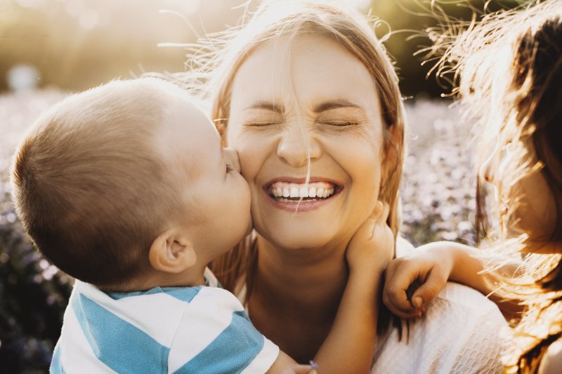 woman smiling in the sunlight with kids