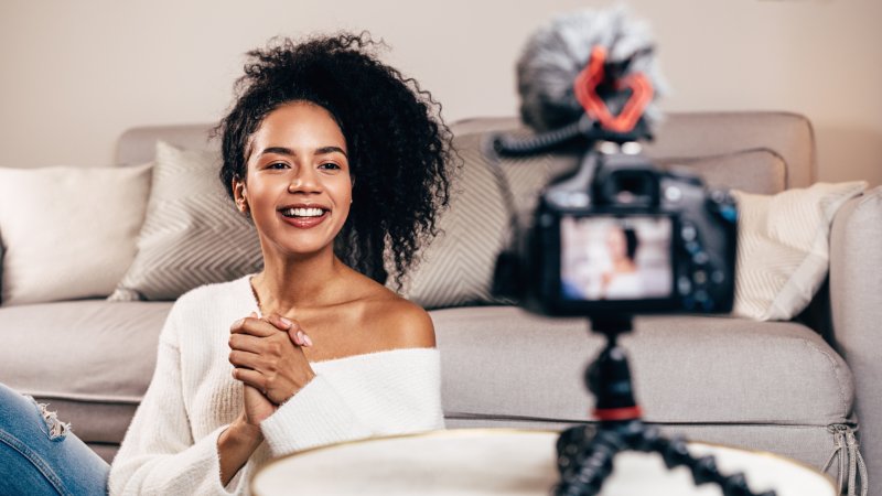 person smiling while being recorded by camera